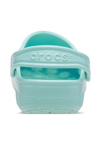 Jasnoniebieskie sandały Crocs z uniesioną, kropkowaną teksturą. Posiadają tylną strap i otwartą konstrukcję, a nazwa marki jest wytłoczona z boku.