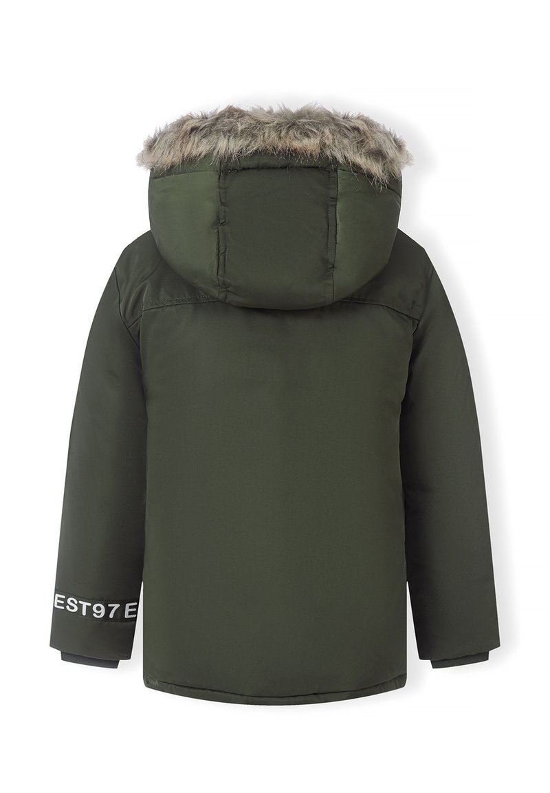 Chaqueta acolchada verde oliva con capucha forrada de piel sintética, mangas largas y detalle de texto "EST97" en la manga izquierda. Textura suave.