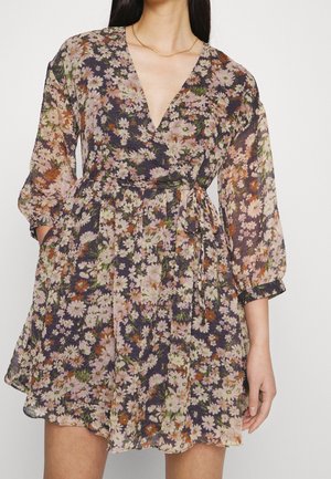 Bloemige jurk van lichtgewicht stof met een v-hals, lange mouwen en een strakke taille. Kenmerkt zich door roze, witte en oranje bloemen op een donkere achtergrond.