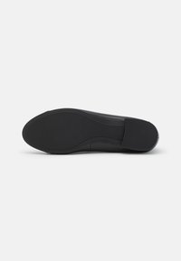 Black shoe sole with a smooth, rounded shape. Textured rubber for grip, featuring a slight curve at the heel and minimal design details.