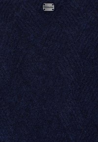 Marinblå ulltyg med en mjuk, strukturerad yta och ett vävt mönster. Har en liten, metallisk Trussardi-logotyp.