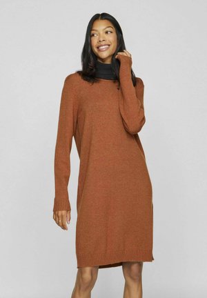Rust-colored sweater dress with long sleeves, ribbed cuffs, and hem; soft texture, relaxed fit, and a round neckline.