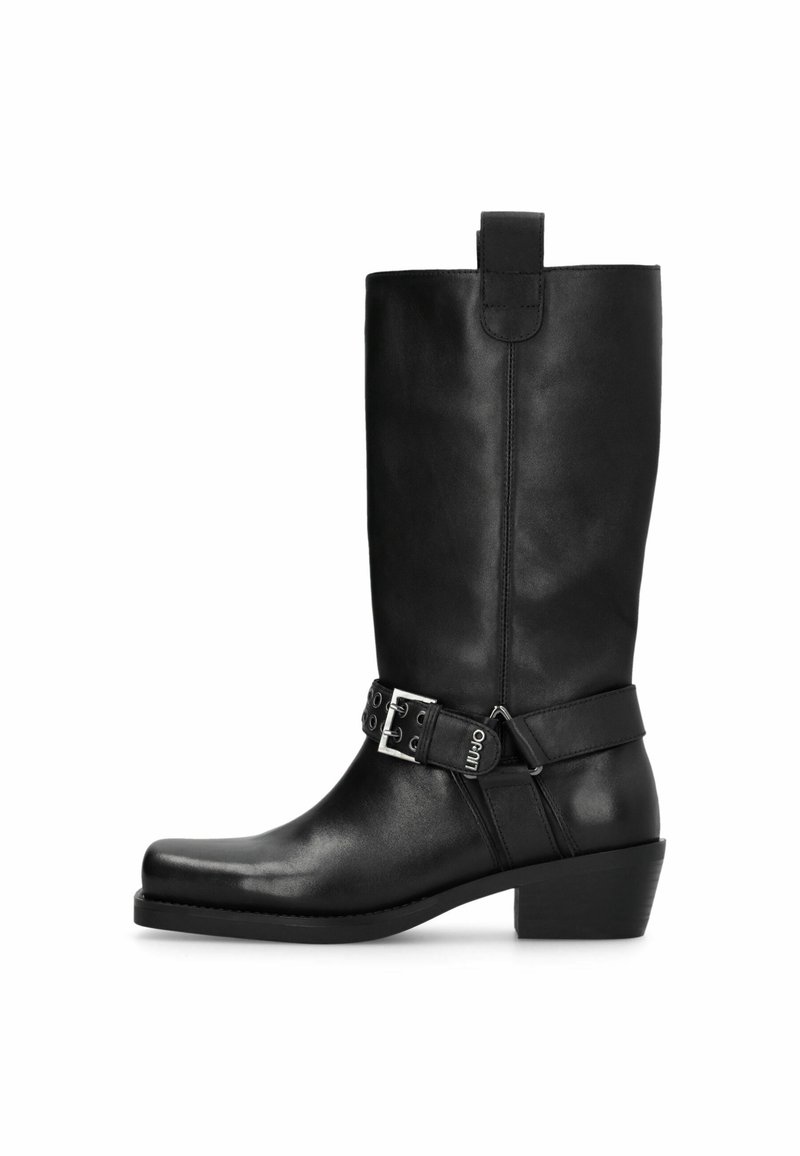 Bota de cuero negro hasta la rodilla con puntera redondeada, tacón medio, detalle de hebilla lateral y lengüeta en la parte superior. Textura suave con acabado brillante.