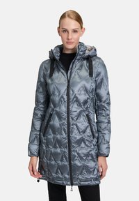 Metallisch grijze gewatteerde pufferjas met capuchon, een rits aan de voorkant en nep leren accenten. Voorzien van twee zijzakken met ritsen.