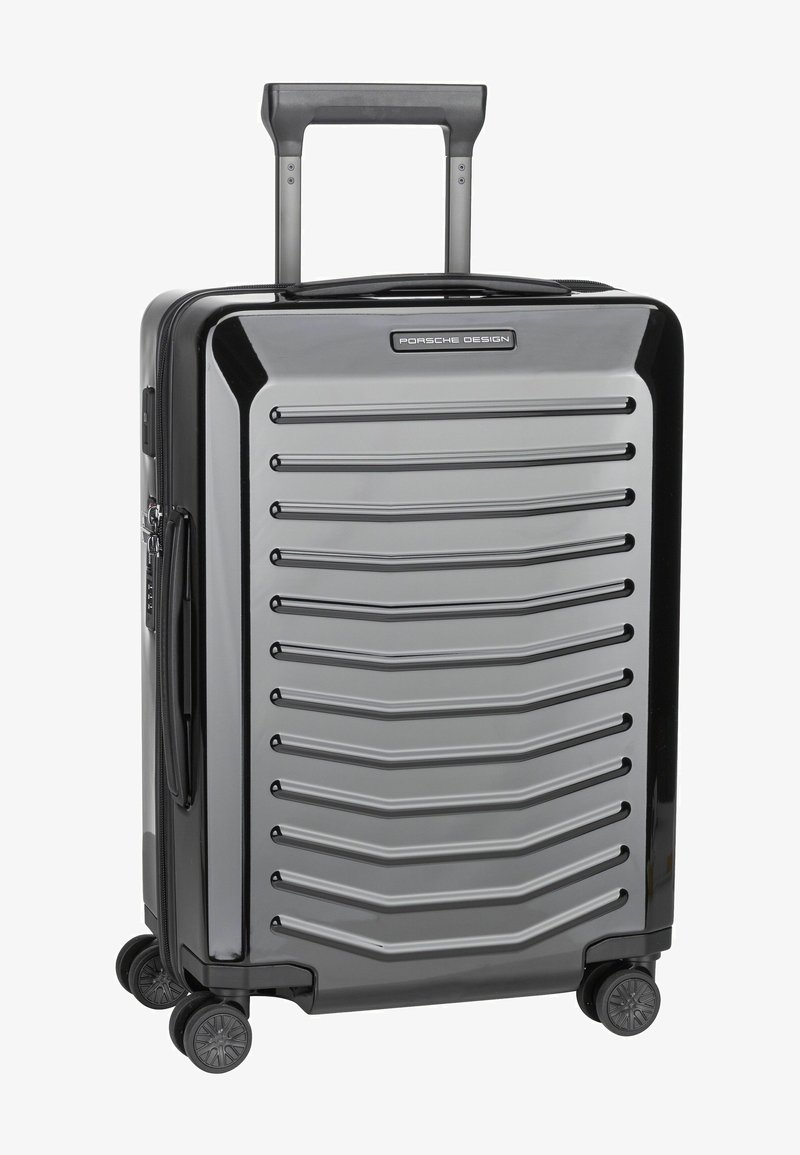 Gray hard-shell suitcase with horizontal ridges, retractable handle, and four spinner wheels for easy maneuverability.