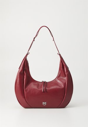 Geantă de umăr din piele roșie, cu o formă curbată, având o deschidere cu fermoar și accente din metal argintiu. Textură netedă, cu un design minimalist.