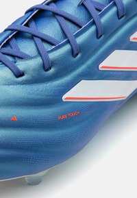 Scarpini da calcio blu con superficie testurizzata, caratterizzati da tre strisce bianche e dettagli arancioni "PURE TOUCH" sul lato. Design con lacci.