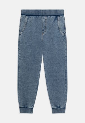 Pantalon jogger en denim bleu avec taille et poignets élastiques, poches avant et détails de coutures visibles.