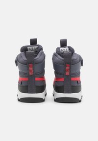 Hohe Sneakers in Dunkelgrau mit roten Akzenten, ausgestattet mit einer strukturierten Oberfläche, gepolstertem Kragen und kontrastierender weißer Sohle.