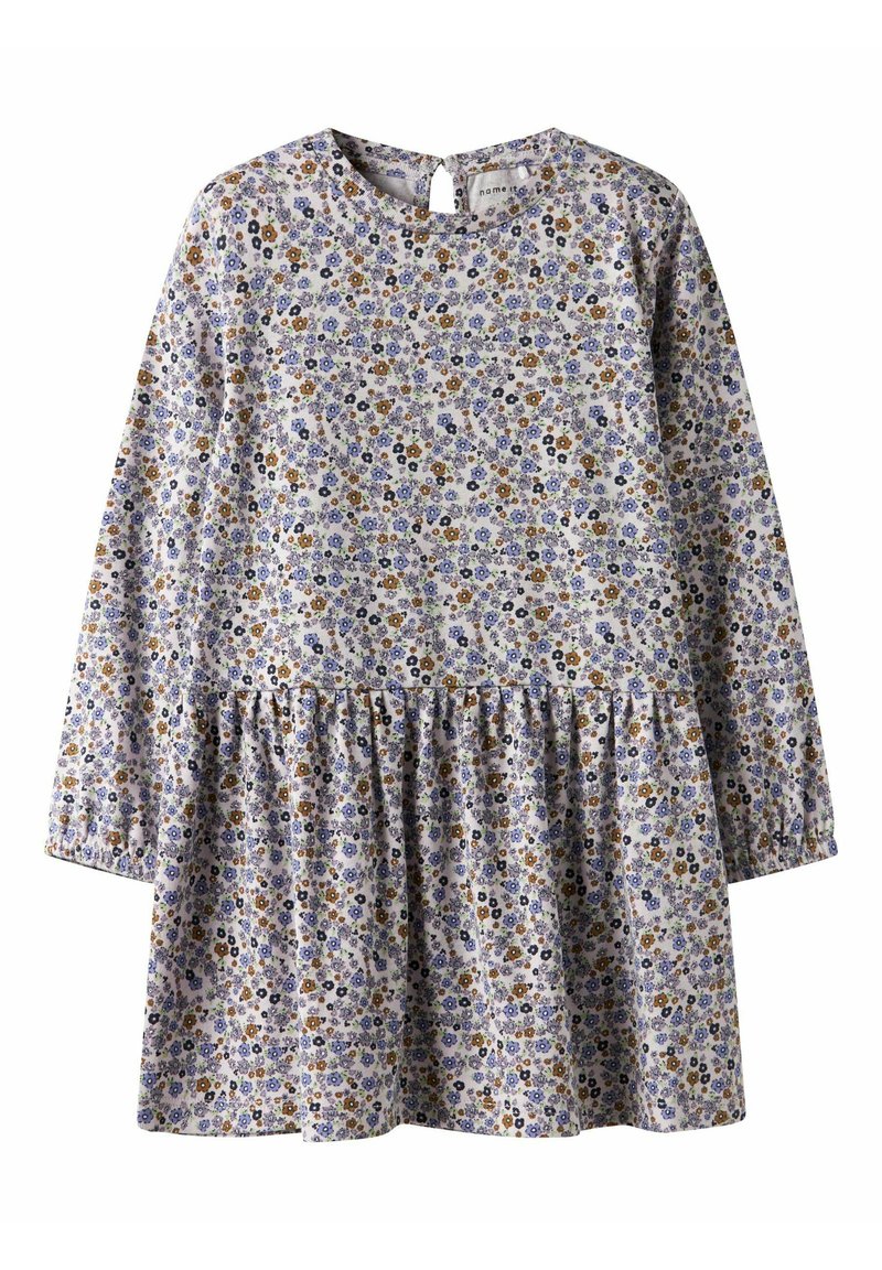 Kjole med blomstermønster, lange ermer, rund hals og et rynket skjørt. Fargene inkluderer lilla, blått, gult og brunt på en lys bakgrunn.