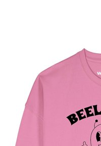 Roze sweatshirt met een ronde halslijn en verlaagde schouders. Voorzien van een zwarte grafische print met de tekst "BEEL". Gemaakt van zacht katoen.