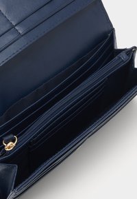 Portafoglio blu navy in pelle liscia, dotato di più slot per carte, un compartimento con zip e cuciture rinforzate.