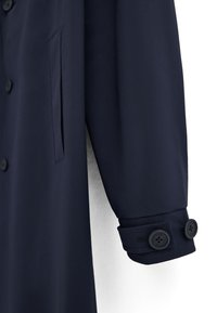 Marineblauer Mantelärmel mit knöpfbarer Manschette, die zwei schwarze Knöpfe und eine vertikale Einschubtasche auf der Vorderseite aufweist.