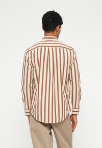 Langärmliges Hemd mit vertikalen braunen und cremefarbenen Streifen, mit spitzem Kragen, geknöpften Manschetten und abgerundetem Saum.