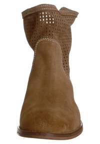 Stivale alla caviglia in suede marrone con design perforato, punta arrotondata, cuciture a contrasto e suola piatta. La superficie testurizzata offre una finitura morbida.