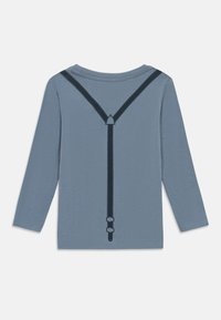 Long-sleeve shirt in light blue fabric featuring a dark blue suspenders design with stitching details, displayed from the back.