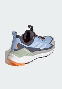 Chaussure de sport bleu et grise avec tissu texturé, accents orange, col rembourré et semelle robuste. Comprend le logo et la marque Gore-Tex.