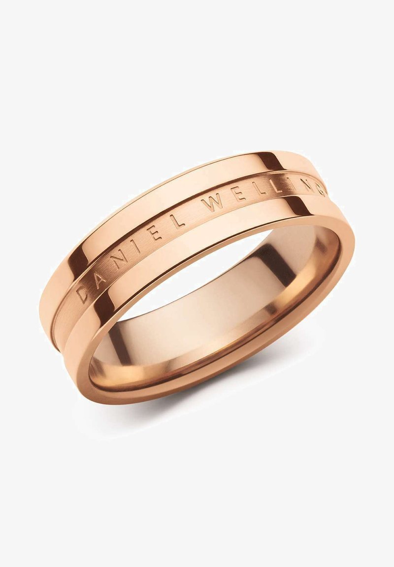 Ruusu kultainen sormus, jossa on kaksi kahta nauhaa, joiden pinta on kiillotettu ja ulkopuolella on kaiverrettu "DANIEL WELLINGTON" -yksityiskohta.