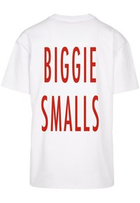 Hvid bomulds T-shirt med fed rød tekst på ryggen, der siger "BIGGIE SMALLS." Klassisk rund halsudskæring og korte ærmer. Enkel design.