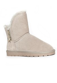 Stivaletto in suede beige con morbida fodera in shearling, tirazip a forma di stella dorata, suola in gomma testurizzata e dettagli cuciti sui bordi.