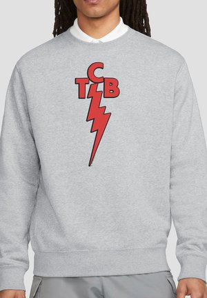 Person wearing light gray sweatshirt with red lightning bolt and letters "CTCB" on the chest.