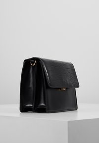 Borsa a tracolla nera in finta pelle di coccodrillo con una forma strutturata, dettagli in oro e chiusura a soffietto. Texture liscia e design elegante.