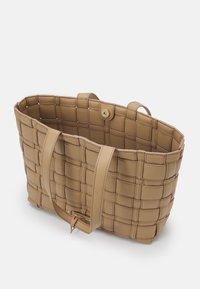 Borsa a tote intrecciata in materiale sintetico beige, con due lunghe maniglie e chiusura a bottone. Presenta un design strutturato e un motivo a griglia prominente.