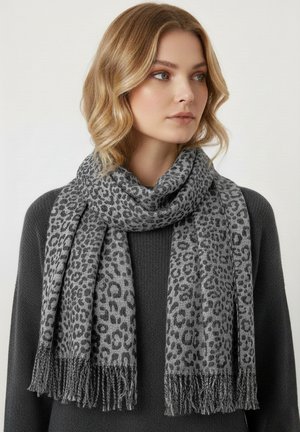 Gray leopard print scarf featuring a soft texture, fringed edges, and a rectangular shape, worn loosely around the neck.