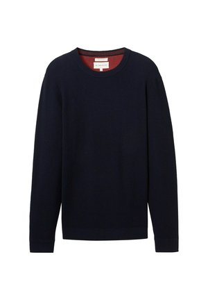 Pull à côtes bleu marine avec des manches longues et un col rond. Le col intérieur présente une bordure contrastante rouge. Étiquette visible.