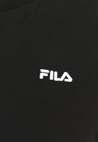 Tessuto a coste nero con il logo "FILA" ricamato in bianco. Presenta un design a girocollo e una texture liscia.