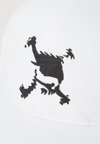 Baltas skrybis su dideliu juodu logotipo dizainu, pagamintas iš tekstūruoto medžiagos, su lygiu paviršiumi ir struktūrine forma.