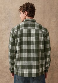 Groen-wit geruit overhemd met een klassieke kraag, lange mouwen en een zachte, gestructureerde stof, voorzien van knoopmanchetten en een rechte zoom.