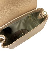 Borsa in pelle beige aperta, che mostra l'interno in tessuto marrone chiaro liscio con tracolla arrotolata abbinata e dettagli in metallo dorato.