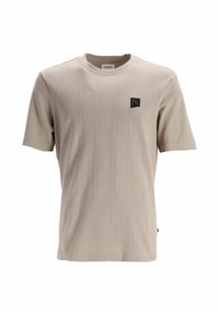 T-shirt beige à manches courtes avec un motif diagonal texturé, col rond, et un écusson logo noir sur le côté gauche de la poitrine.