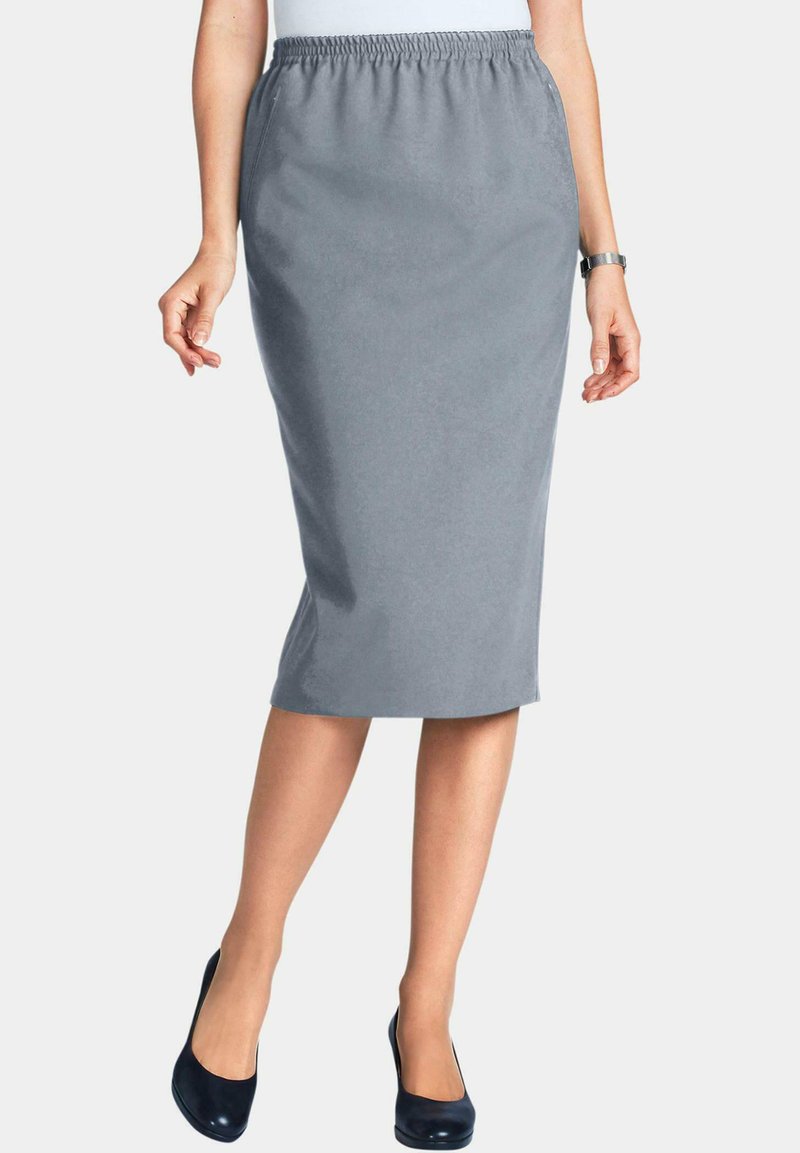 Graue Midirock mit elastischem Bund, glatter Textur und geradem Schnitt. Getragen mit navyfarbenden Absätzen, die eine figurbetonte Silhouette zeigen.