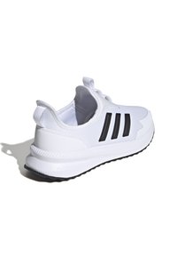 Zapatilla blanca con diseño de tres rayas negras, parte superior de malla, suela acolchada, punta redondeada y una pestaña en la parte trasera para facilitar el calzado.