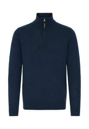 Námornícky modrý pletený pulóver s vysokým golierom a štvrťovým zipsom. Manžety a spodný lem majú rebrované detaily pre zvýšenú textúru.