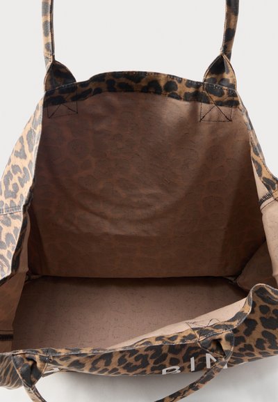 Bolsa de mano de tela con estampado de leopardo, con dos asas, mostrando un interior espacioso y vacío y costuras reforzadas en las asas.