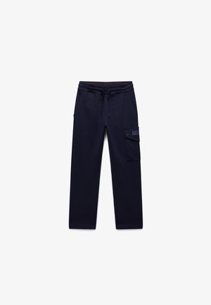 Tamsiai mėlynos laisvalaikio kelnės iš minkštos medžiagos, turi elastingą juosmenį su reguliuojama raišteliu, šonines kišenes ir cargo kišenę ant kojos.