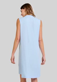 Vestido sin mangas de color azul claro, con un corte relajado, textura suave, de longitud a la rodilla y un diseño sencillo. Sin patrones ni herrajes visibles.