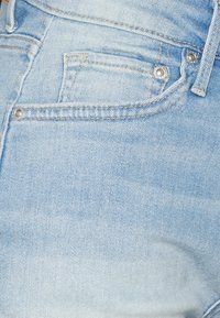 Ljust blå denimjeans med en klassisk design med fem fickor, synlig sömnad och metallknappdetaljer vid midjan.