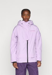 Giacca da esterno lilla con zip frontale, cappuccio e grandi tasche. Presenta una cerniera nera a contrasto e il logo del marchio sul petto.