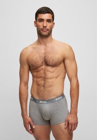 Boxeri scurți din bumbac gri, cu un elastic pe talie cu logo, design ajustat și o textură netedă, punând în evidență un stil modern și minimalist.