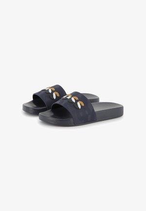 Donkerblauwe slide sandalen met een patroon op de band, voorzien van meerkleurige ronde accenten in bruin, wit en zwart aan de bovenkant. Getextureerde zool.