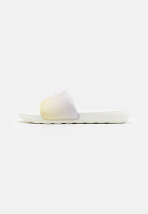 Chancla con suela de goma blanca, que presenta una correa suave en un degradado de colores pastel púrpura y amarillo, con detalles de costura.