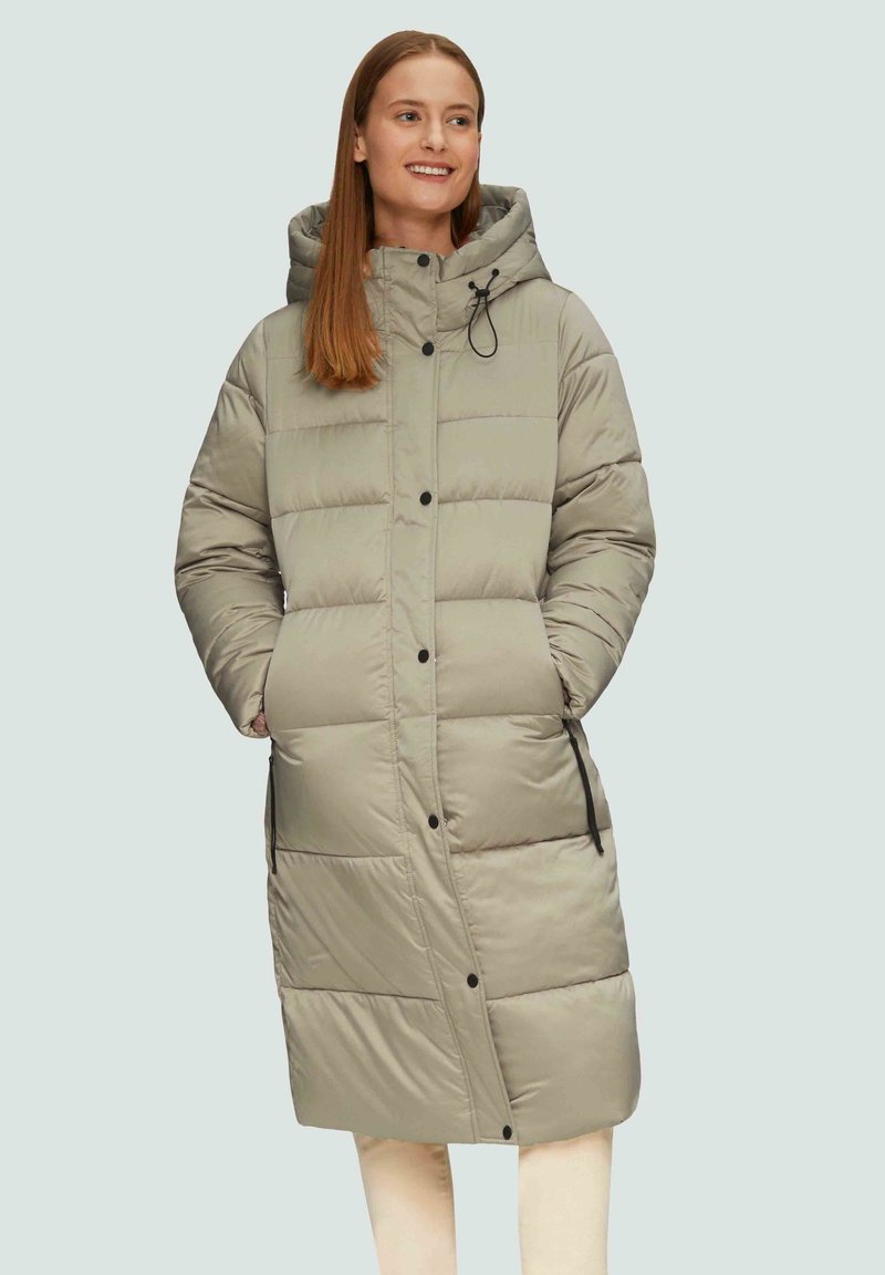 Langer, gepolsterter Mantel in Hellgrau. Besitzt eine Kapuze, vordere Knöpfe, zwei Seitentaschen und strukturierten Nähten mit horizontalen Paneelen.