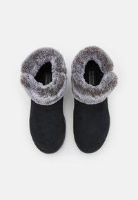 Stivali ankle in suede nero con un risvolto in pelliccia sintetica grigia, punta rotonda e soletta imbottita. Progettati per il comfort con una finitura strutturata.