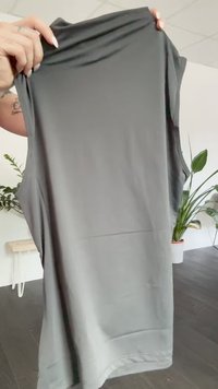 Graues ärmelloses Oberteil aus glattem Stoff, mit Rundhalsausschnitt und lockerem Schnitt. Keine sichtbaren Muster oder Hardware-Details.