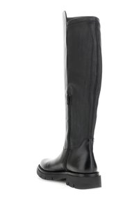 Bota de cuero negra hasta la rodilla con cremallera lateral, suela gruesa con taco y punta redondeada, mostrada desde un ángulo lateral trasero.