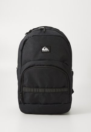 Black Quiksilver backpack with front zip pocket, padded main compartment, and logo patch on plain white background.
